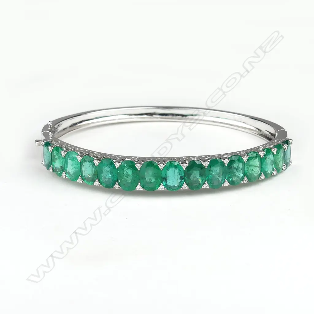 An 18ct white gold emerald and diamond hinged bangle Image 1++