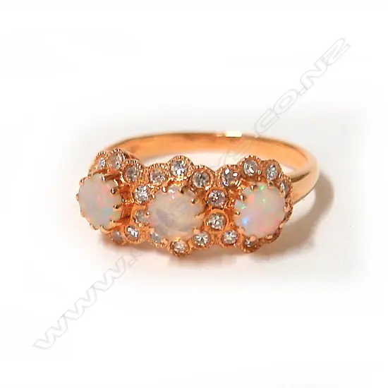 A modern 18ct. rose gold opal and diamond three-cluster ring