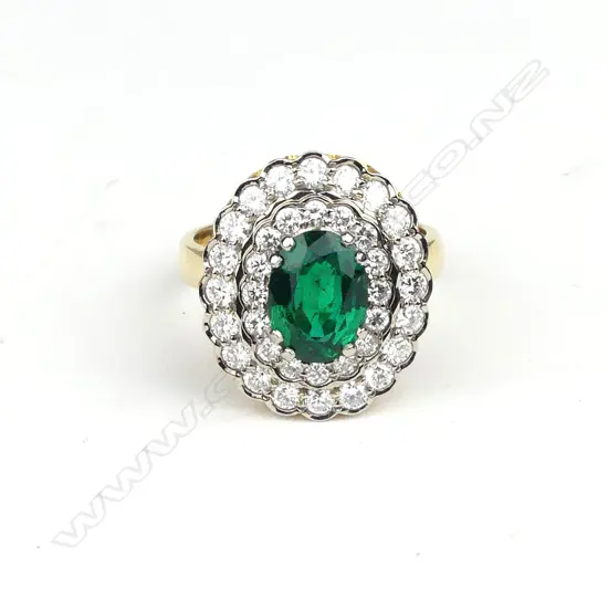 An impressive 18ct. yellow and white gold emerald and multi-diamond cluster ring
