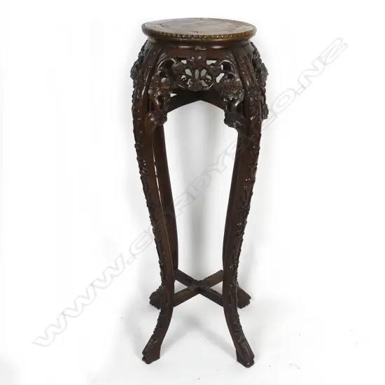 An Oriental carved rosewood torchiere