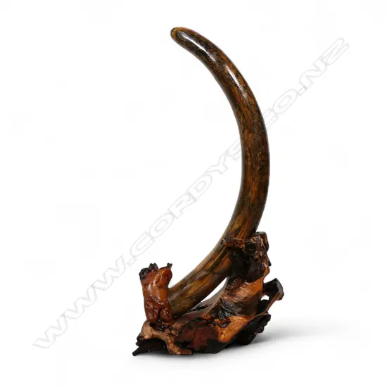 An ancient full woolly mammoth tusk on carved stand,