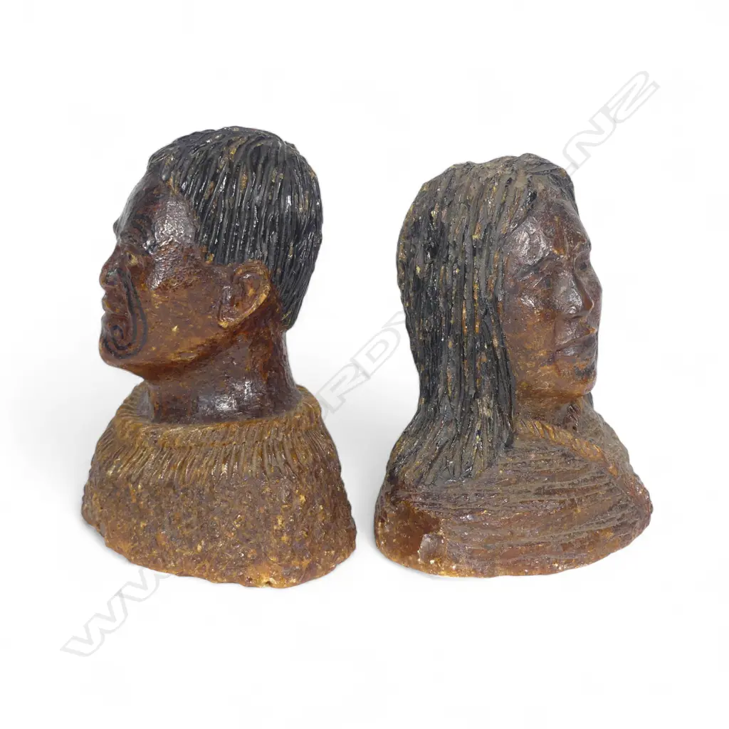 A pair of late 19thC large carved kauri gum busts of a Māori chief and chieftainess, naturalistically represented with black staining to their hair and moko, both represented with a muka cloak wrapped to their shoulders. Minor chipping to edges. H's.105mm. Provenance: From the John Perry estate. Image 1++