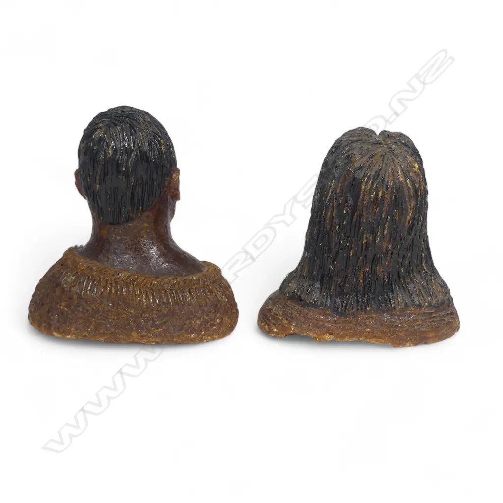 A pair of late 19thC large carved kauri gum busts of a Māori chief and chieftainess, naturalistically represented with black staining to their hair and moko, both represented with a muka cloak wrapped to their shoulders. Minor chipping to edges. H's.105mm. Provenance: From the John Perry estate. Image 1++