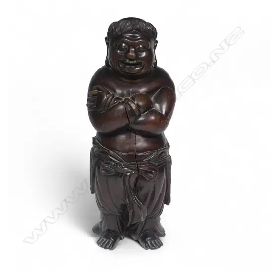 A 19thC Chinese carved hardwood Buddha figure standing with arms crossed wearing a drape around his waist. Old shrinkage crack to front and repair to foot. Good old patina. H.325mm.