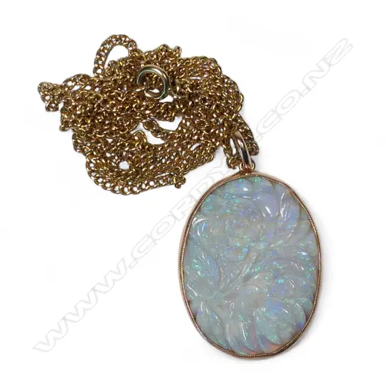 A 9ct gold framed carved large opal panelled pendant on 9ct gold chain,