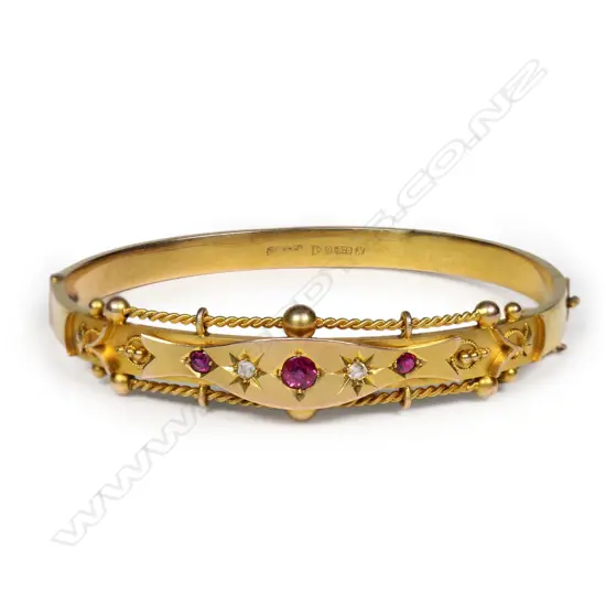 An early 20thC 9ct yellow gold fancy hinged bangle,