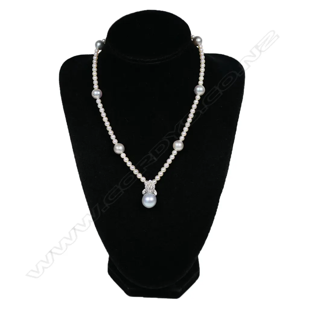 A pearl and diamond set necklace - a single strand of seventy-six 4mm Akoya type cultured pearls (white-pinkish with silver overtones and good lustre), with seven 10mm South Sea pearls (greyish-bluish with good lustre and moderate blemishes), interspersed with the smaller pearls, with a suspended 18ct white gold Bishop's mitre design pave set with diamonds supporting a 12mm bluish grey South Sea pearl. TDW. 0.31ct. The white gold clasp incorporated into one of the South Sea pearls. 39cm long Image 1++
