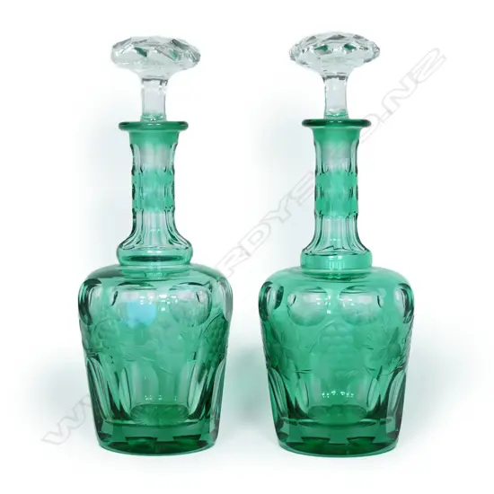 A pair of antique green glass decanters,