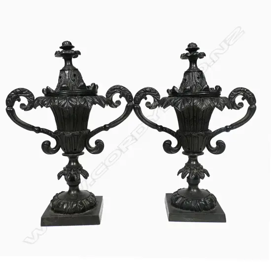 A pair of Regency period bronze pastille burners, of campana urn shape - with acanthus capped scroll handles and raised on palm frond knopped columns from square plinth bases. The covers with conforming palm fronds and foliate finials. H.190mm,