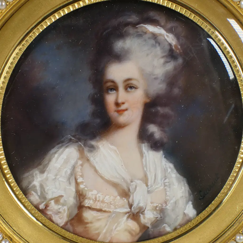 A quality 19thC portrait miniature of a lady in gilt brass jewelled frame - she wears a silk sleeved dress and scarf, a ribbon to her elaborate hair. The frame finely machine engraved and with an encircling band of faux seed pearls. Dia.107mm. Image 1++