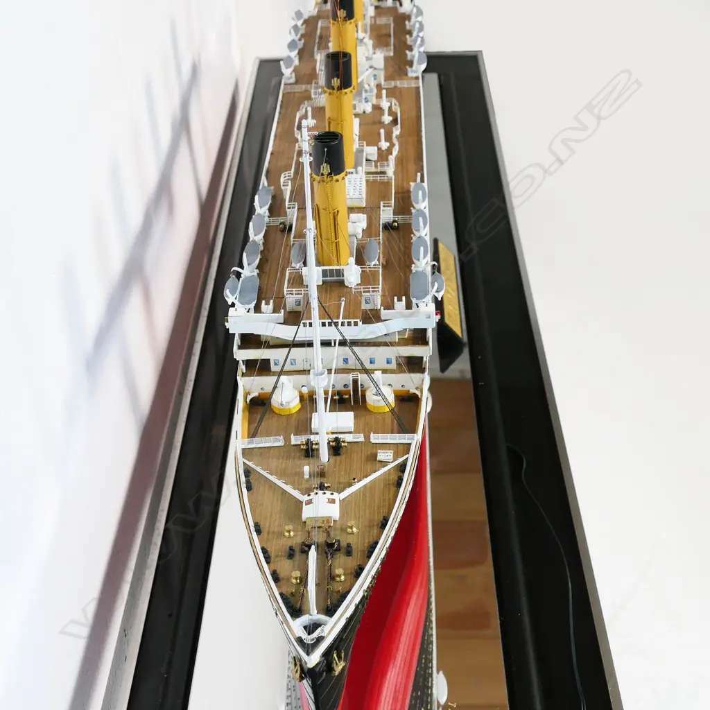 A model of RMS Titanic - on mirrored base and table, together with eight Titanic books and a jigsaw puzzle. L.1375mm. Image 1++