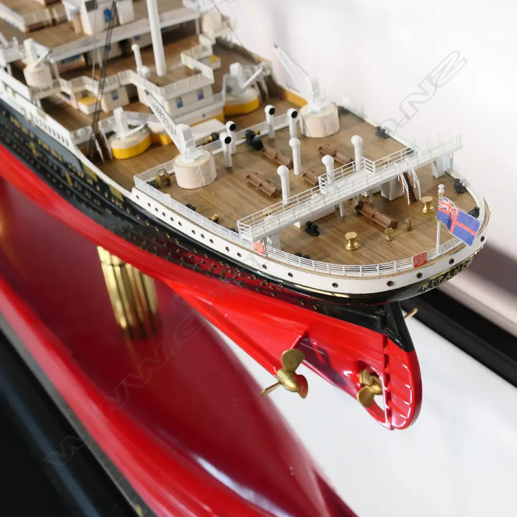 A model of RMS Titanic - on mirrored base and table, together with eight Titanic books and a jigsaw puzzle. L.1375mm. Image 1++