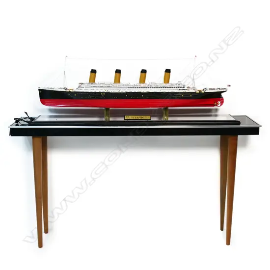 A model of RMS Titanic - on mirrored base and table, together with eight Titanic books and a jigsaw puzzle. L.1375mm.