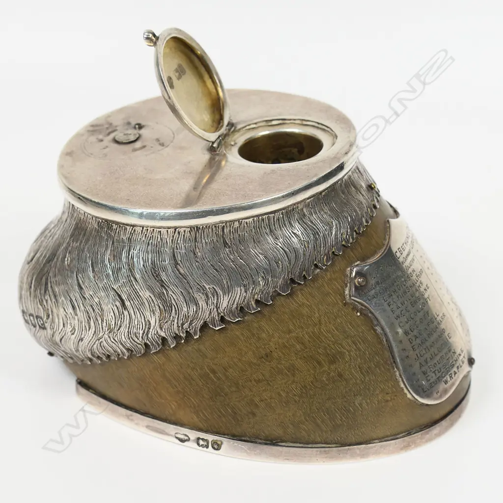 An historic Boer War presentation silver mounted horses hoof inkwell - the applied silver shield presentation engraved with multiple names including Lt. Col. F.C. Bethune Major, Major R.L.Walter and 31 other names. The silver top with missing attachment and small lidded inkwell above an applied silver mount modelled and engraved as horses hair. Silver horse shoe to the base. Image 1++