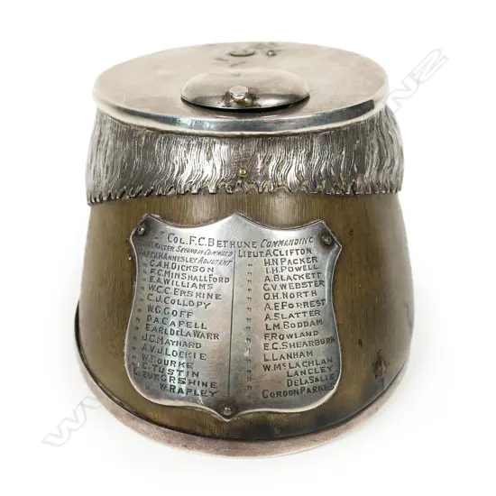 An historic Boer War presentation silver mounted horses hoof inkwell - the applied silver shield presentation engraved with multiple names including Lt. Col. F.C. Bethune Major, Major R.L.Walter and 31 other names. The silver top with missing attachment and small lidded inkwell above an applied silver mount modelled and engraved as horses hair. Silver horse shoe to the base.