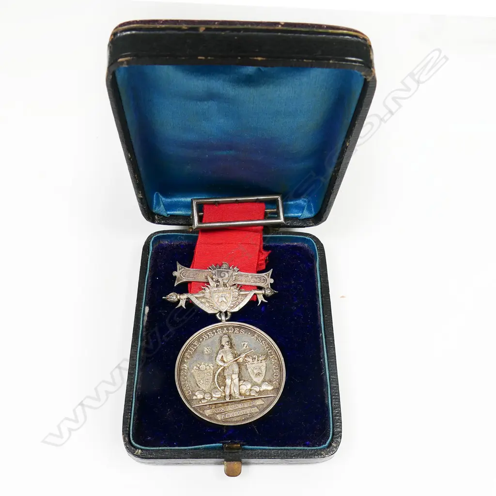Anton Teutenberg UFBA medal to Benjamin Hounslow - with his name on the medal suspender and bar, contained in box of issue. The medal named to Benjamin Hounslow from the Masterton Fire Brigade 1880. Benjamin was a cabinetmaker who died at Masterton 1893 aged 32/3. The medal is an excellent early example of Teutenberg's work and has been hand engraved by him. Image 1++