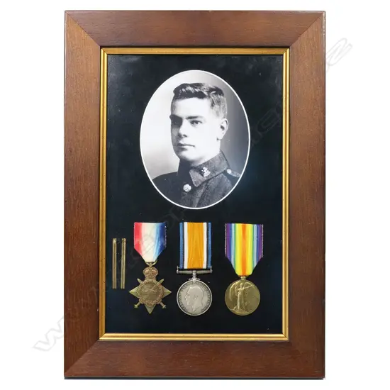 WW1 1914-15 trio of medals in a modern frame - with copy photo and 2 wound stripes. The medals all correctly impressed 10/409 SJT L A KINZETT NZEF. Louis Kinzett was living in Wanganui working as a wood turner when he enlisted in the Wellington Infantry in October 1914. He served at Gallipoli where he was wounded on 5 May 1915. He is known to have been involved in a brutal bayonet charge earlier. After recovery in Egypt he was returned to Gallipoli 3 months later, narrowly missing his Battalions near obliteration at Chunuk Bair on 8 August. His second wounding was in France on 15 September 1916.