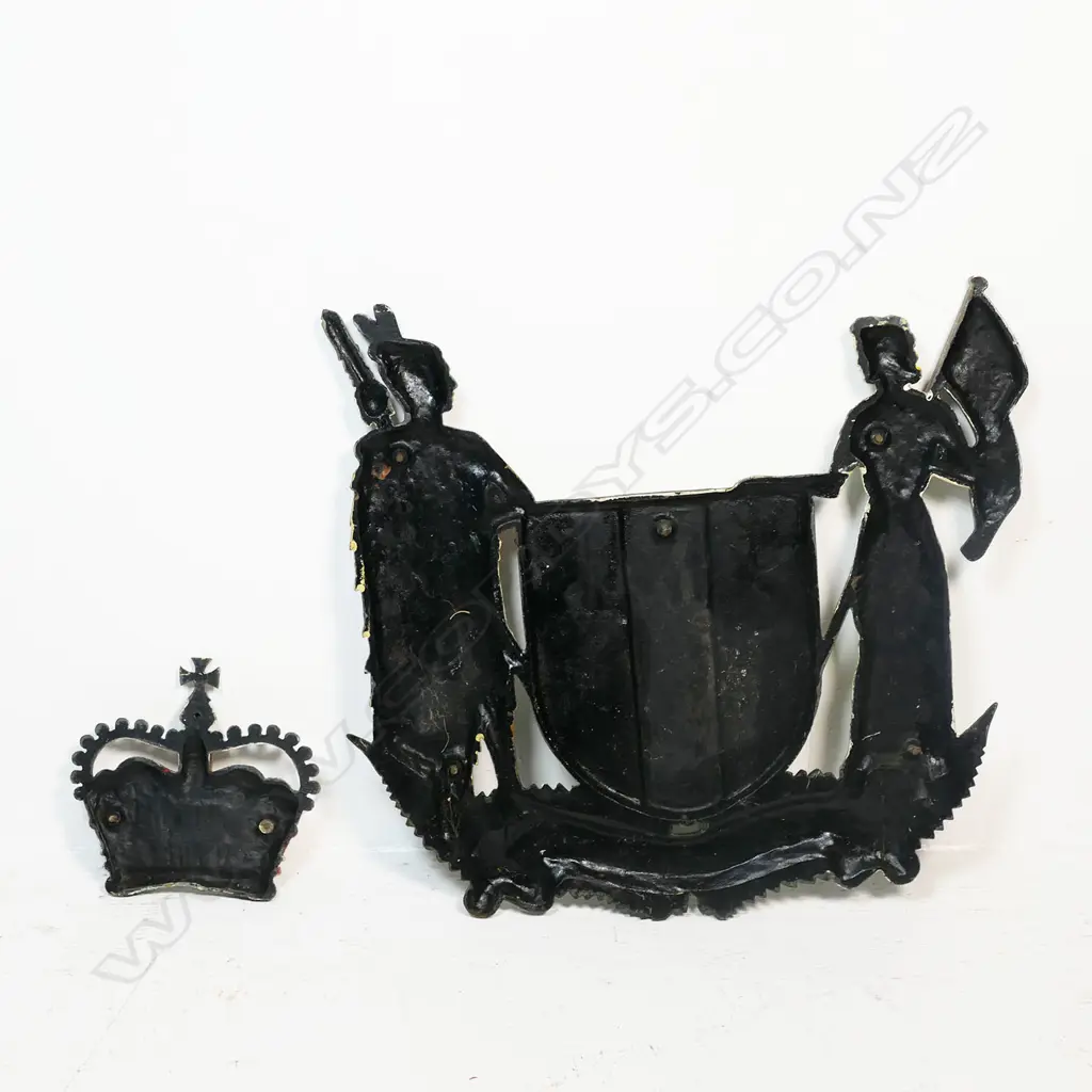 A vintage painted heavy cast bronze New Zealand Coat of Arms - the design reflects New Zealand's history as a bicultural nation, with Zealandia, a European female figure on one side and a Māori Rangatira (chief) on the other. The symbols on the central shield represent New Zealand's trade, agriculture and industry, and a Crown represents New Zealand's status as a constitutional monarchy. 610 x 590mm. Image 1++