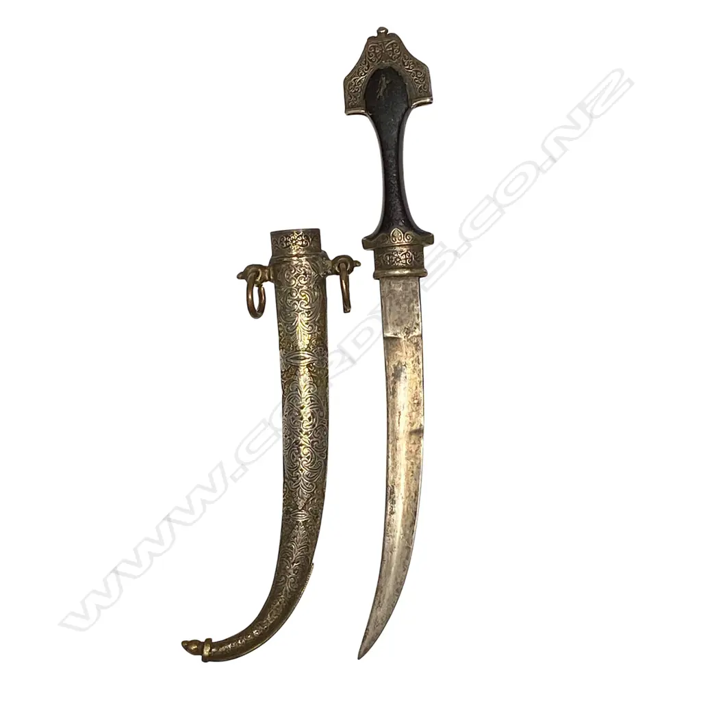 A Middle Eastern dagger - silvered brass heavily embossed scabbard, aged wooden handle and curved double edge blade. L.410mm. Image 1++