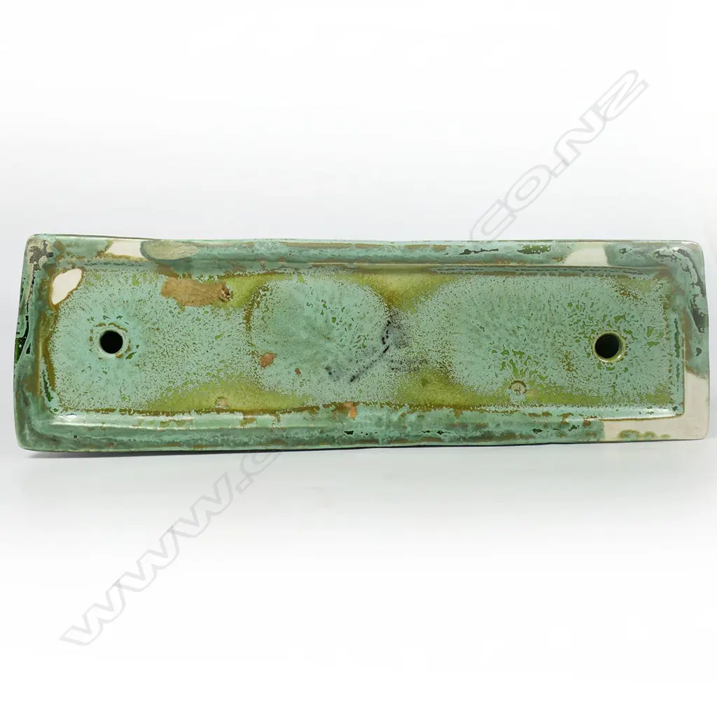 A Clarice Cliff Art Deco green art glaze boar sculpture - produced in 1936 for Wilkinson's Ltd. Stylised form, on a tapered curved base, the variable green glaze with pale matt and mid-green gloss highlights. L.246mm. H.174mm. Illustrated in Howard & Pat Watson's book 'collecting Art Deco Ceramics', Kevin Francis Publishers, London, 1993. Image 1++