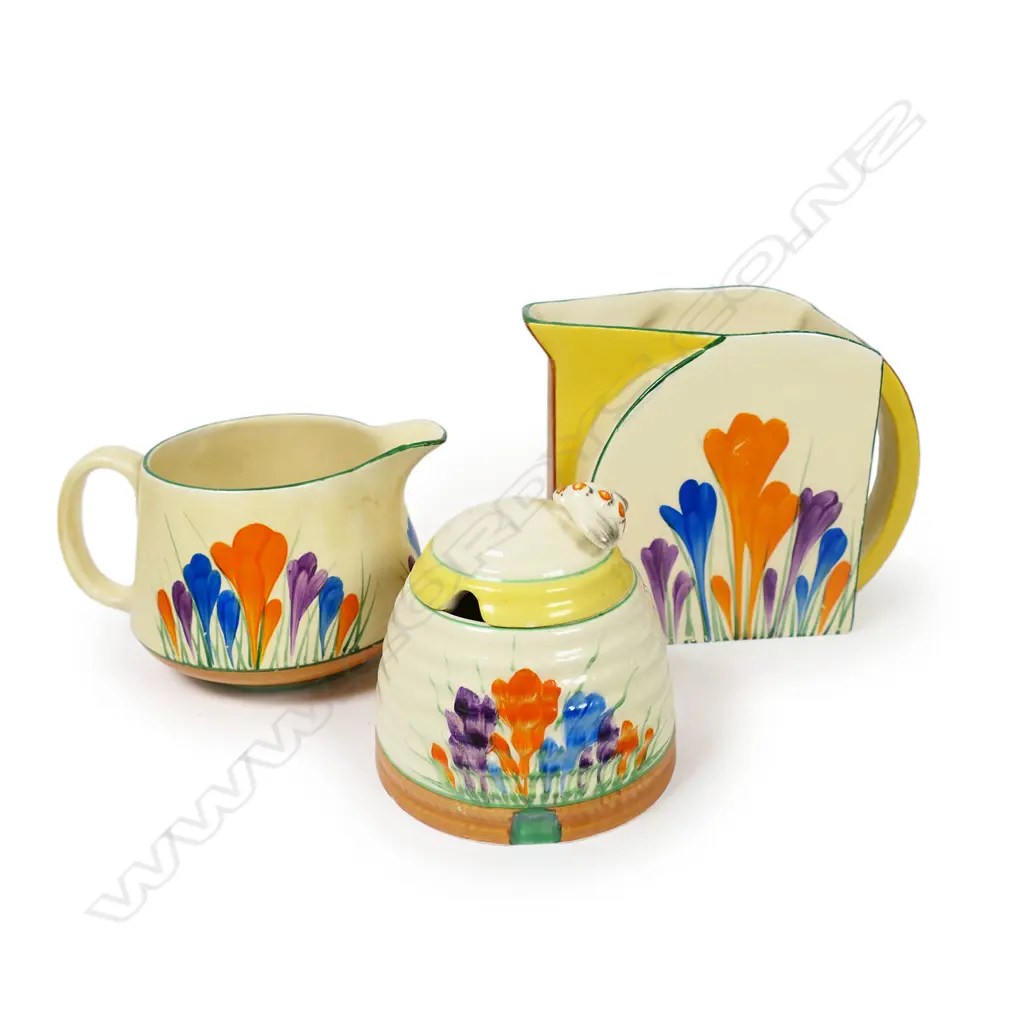 Three Clarice Cliff Crocus pattern pieces - includes a Stamford shape (H.120mm) and other milk jugs, together with a beehive lidded honey pot.H.95mm. Image 1++
