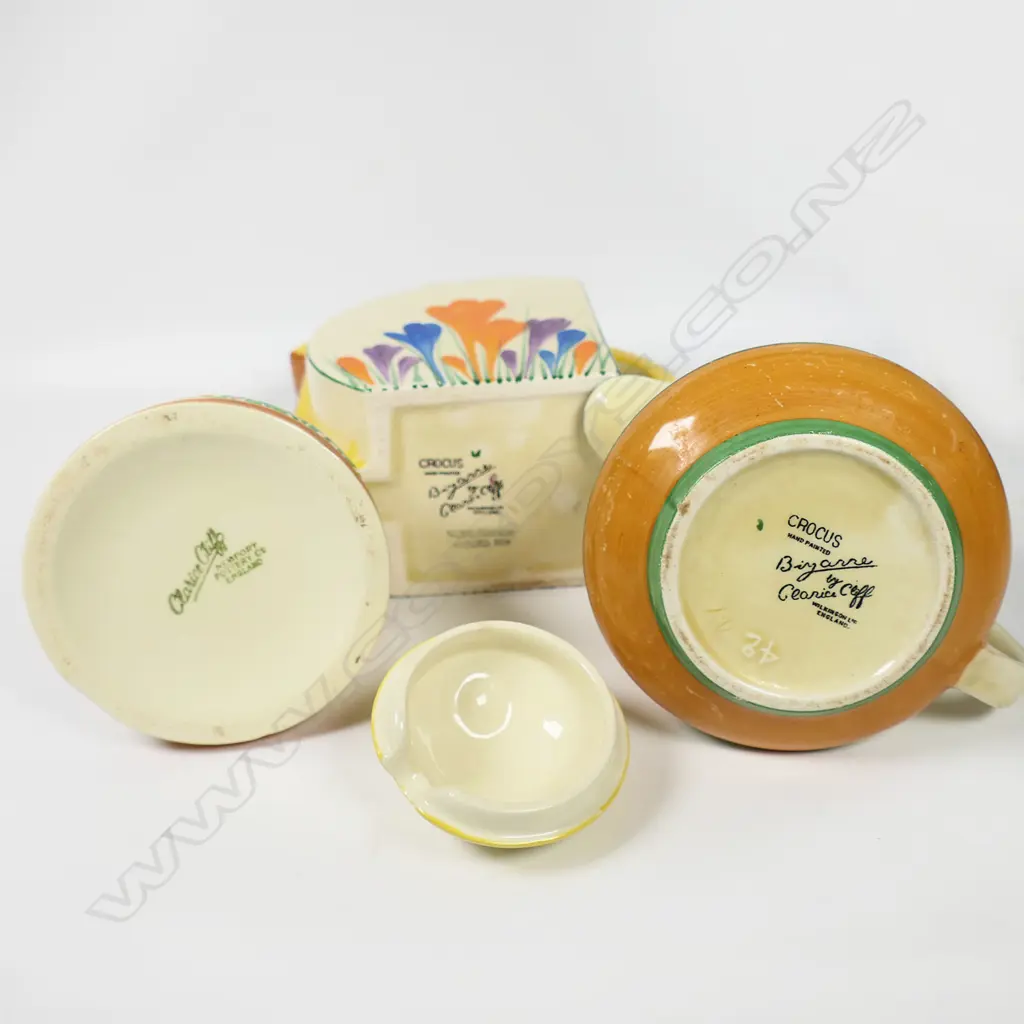 Three Clarice Cliff Crocus pattern pieces - includes a Stamford shape (H.120mm) and other milk jugs, together with a beehive lidded honey pot.H.95mm. Image 1++