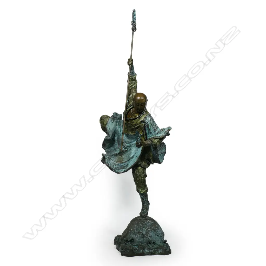 A highly decorative and energetic bronze of a bodhisattva Shaolin monk - wielding his khakkhara staff in his raised arm and manifesting a flaming pearl in his left hand, stamped under the hem of his flaring cloak with two undeciphered zhuanshu script seal marks. The surface treatments including cold painting and enhanced verdigris patination. The poised stance above rising and falling waves mirroring the Buddhist concept of finding balance and equanimity amidst change, the ebb and flow - life and death. H.1010mm, Image 1++
