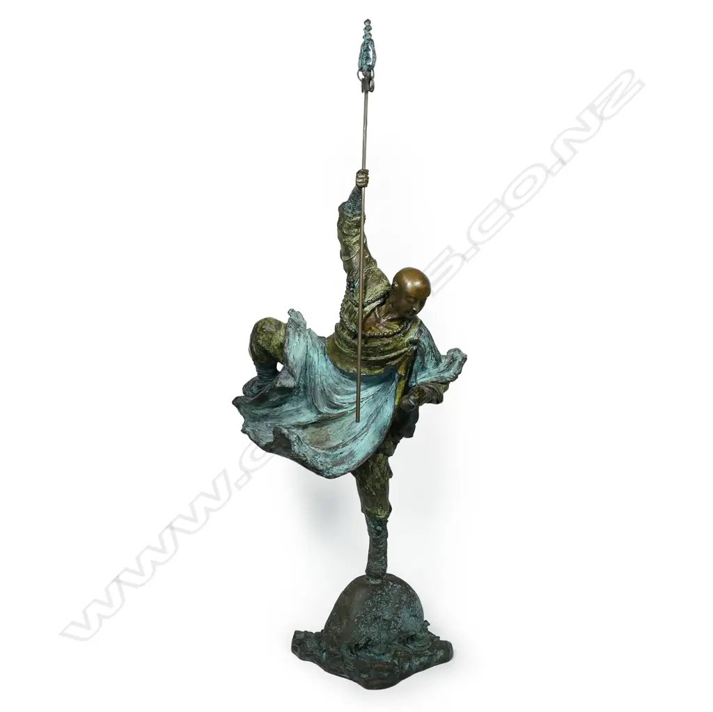 A highly decorative and energetic bronze of a bodhisattva Shaolin monk - wielding his khakkhara staff in his raised arm and manifesting a flaming pearl in his left hand, stamped under the hem of his flaring cloak with two undeciphered zhuanshu script seal marks. The surface treatments including cold painting and enhanced verdigris patination. The poised stance above rising and falling waves mirroring the Buddhist concept of finding balance and equanimity amidst change, the ebb and flow - life and death. H.1010mm, Image 1++