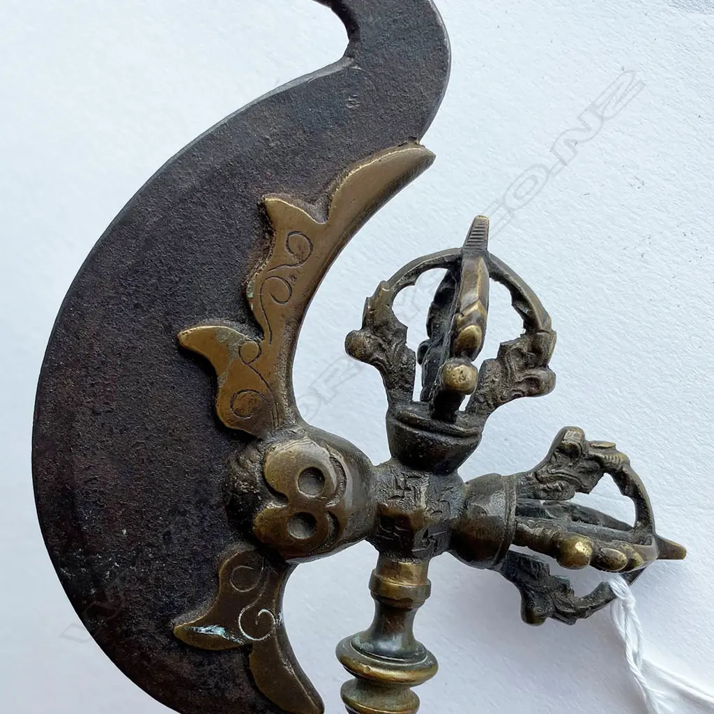 A Tibetan Buddhist kartika (ceremonial knife) on ornate axe shaft, 19thC - steel crescent blade set in bronze mounts incorporating swastika engraved octagon mount and vajra terminals on a double baluster knopped shaft. L.340mm. Image 1++