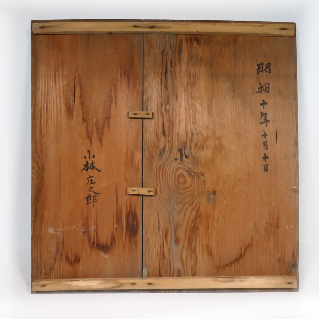 One of a matched pair, a massive Japanese Imari porcelain charger - decorated with madoe panels of 'brocade' patterns, gilt dragon rondel motifs, ancient pines and an unfurling scroll depicting Manchurian cranes in flight between ribbons of mist on a background of jade and gold cloud forms. The reverse rim painted with chrysanthemum and blossom branches in iron red and underglaze blue, Dia.600mm. Image 1++