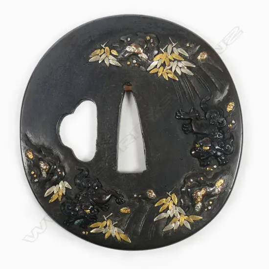 A superb late 18thC/early 19thC Japanese Shibuichi soft metal tsuba - quality high relief gambolling Shishi playing in a waterfall, with gold and silver highlighted foliage. Signed Terumitsu. In fitted box.