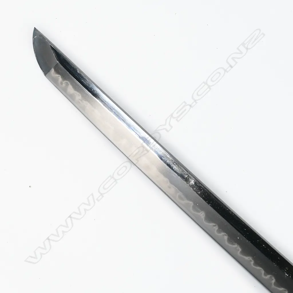 A fine old Japanese katana - possibly 16thC Mino school, unsigned, original polish with healthy undulating gunome temper, no flaws to the blade. Old mounts with Fuchi and Kojiri in dark Shibuichi carved with waves and gold highlights. Menuki of Shakudo and gold in floral design. The iron Tsuba in open design with samurai figures by a bridge. Quality black lacquer saya with maroon Sageo and fine blue/gold silk bag. L. 900mm. Image 1++