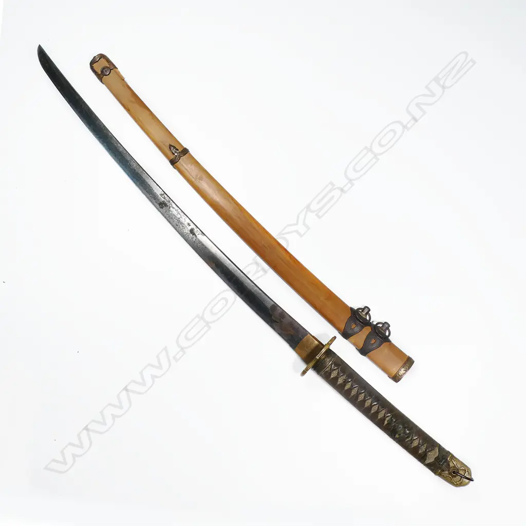 An old katana in tachi mounts (handachi - with cloth bound ray skin covered hilt with tachi kashira, chrysanthemum menuki, chrysanthemum decorated tsuba, the tang with incised and stamped characters, single fixing hole. Overall surface oxidation to blade, multiple nicks to blade edge. In plain wood saya with tachi style koshirae. Blade L.650mm. Overall 925mm. Image 1++