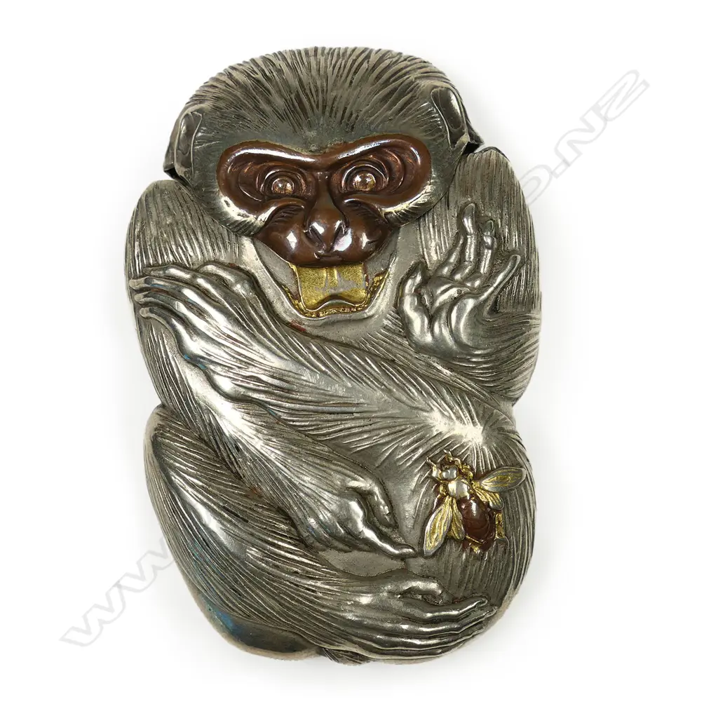 A c.1900 Japanese novelty white metal vesta case - as a monkey, its attention drawn to a bee on its leg. The bee and mouth highlighted in gilt and bronze overlay. H.65mm. Image 1++