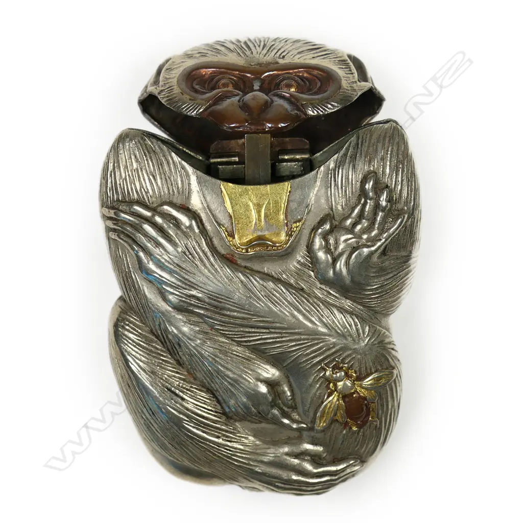 A c.1900 Japanese novelty white metal vesta case - as a monkey, its attention drawn to a bee on its leg. The bee and mouth highlighted in gilt and bronze overlay. H.65mm. Image 1++