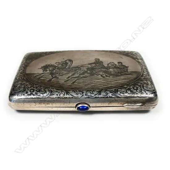 A 19thC Russian niello silver cigarette case - finely decorated with figures in horse drawn sliegh and leafy scrolls. Blue gem to the thumbpiece. Maker's mark for Pyotr Ambrosimov of Moscow 1869 - 1908.