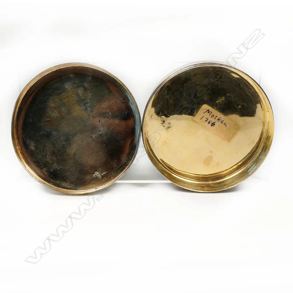 An 18thC Russian silver table box - the lid cast with a relief scene of two women in a treed landscape surrounded by cherubs. Fine engraved border bands. Stamped mark for 1786. Dia.90mm. 212gms. Image 1++