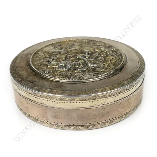 An 18thC Russian silver table box - the lid cast with a relief scene of two women in a treed landscape surrounded by cherubs. Fine engraved border bands. Stamped mark for 1786. Dia.90mm. 212gms.