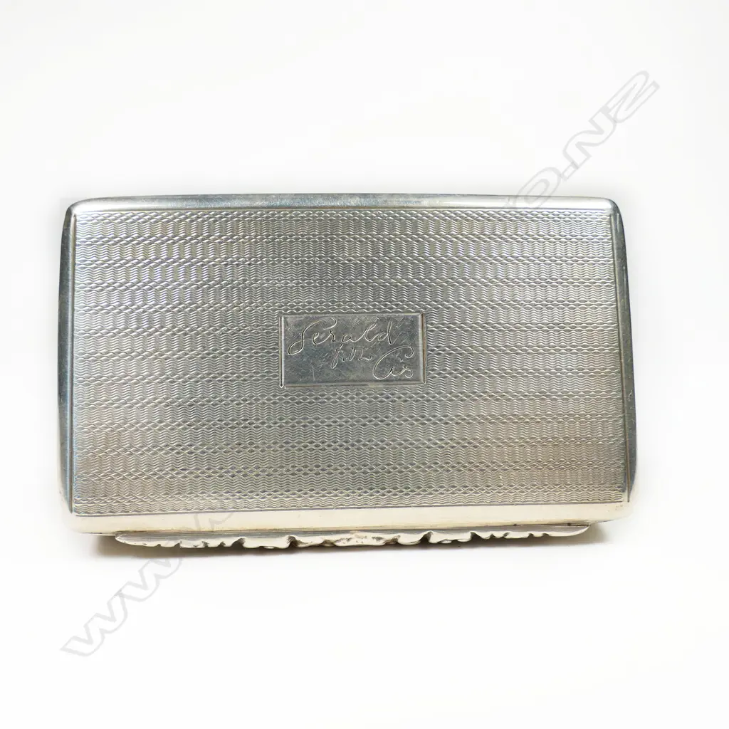 An early 20thC silver Georgian style snuff box - finely machine engraved and with applied floral cast tapered thumb piece. London 1926. W.79mm. 82gms. Image 1++