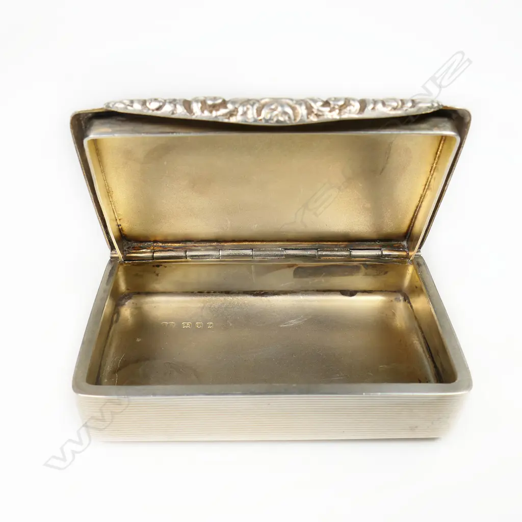 An early 20thC silver Georgian style snuff box - finely machine engraved and with applied floral cast tapered thumb piece. London 1926. W.79mm. 82gms. Image 1++