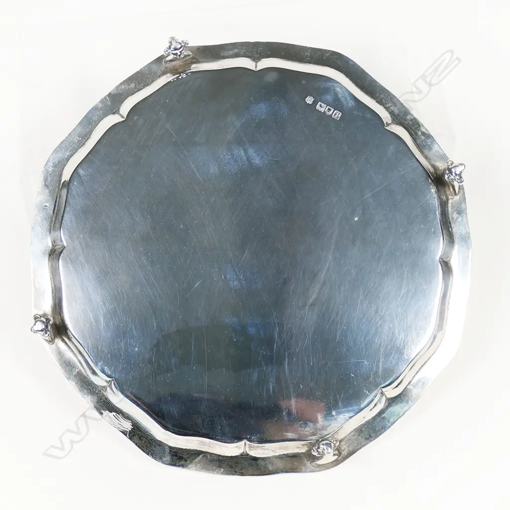 An early 1900s silver salver - gadrooned rim, plain centre, raised four ball and claw feet. London 1910 by Thomas Bradbury & Sons Ltd. 386gms. Dia.200mm. Image 1++