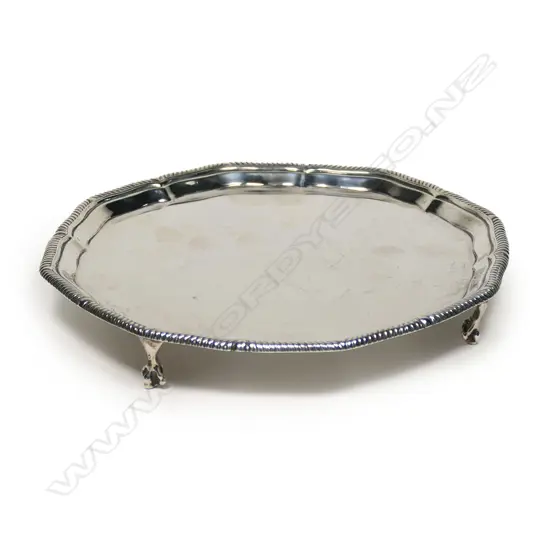 An early 1900s silver salver - gadrooned rim, plain centre, raised four ball and claw feet. London 1910 by Thomas Bradbury & Sons Ltd. 386gms. Dia.200mm.