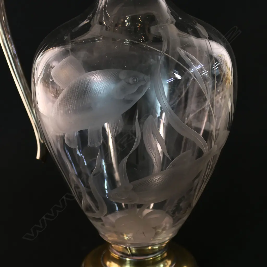 A silver and decorative fish themed cut glass wine ewer - with silver hinged lid, top mount with spout and handle. London 1876 by Jane Brownett & Alexander Jones. The ovoid body finely engraved with fish amongst reeds. On after market period brass steeped foot. H.340mm. Image 1++