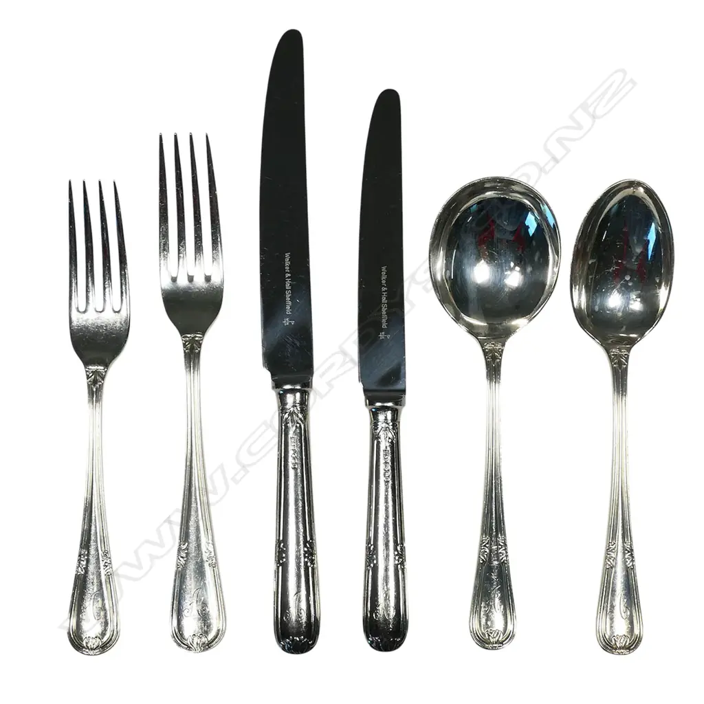 A 12 place 90-piece silver cutlery canteen by Walker and Hall, with eight additional silver plated serving utensils, Sheffield 1972 - double struck leaf and berry pattern with thread edge. Comprising 12 each: table forks, entree forks, dessert spoons, soup spoons, teaspoons, with six table spoons and 12 silver handled stainless bladed table knives and 12 entree knives. Total weight excluding knives 4255gms. Image 1++
