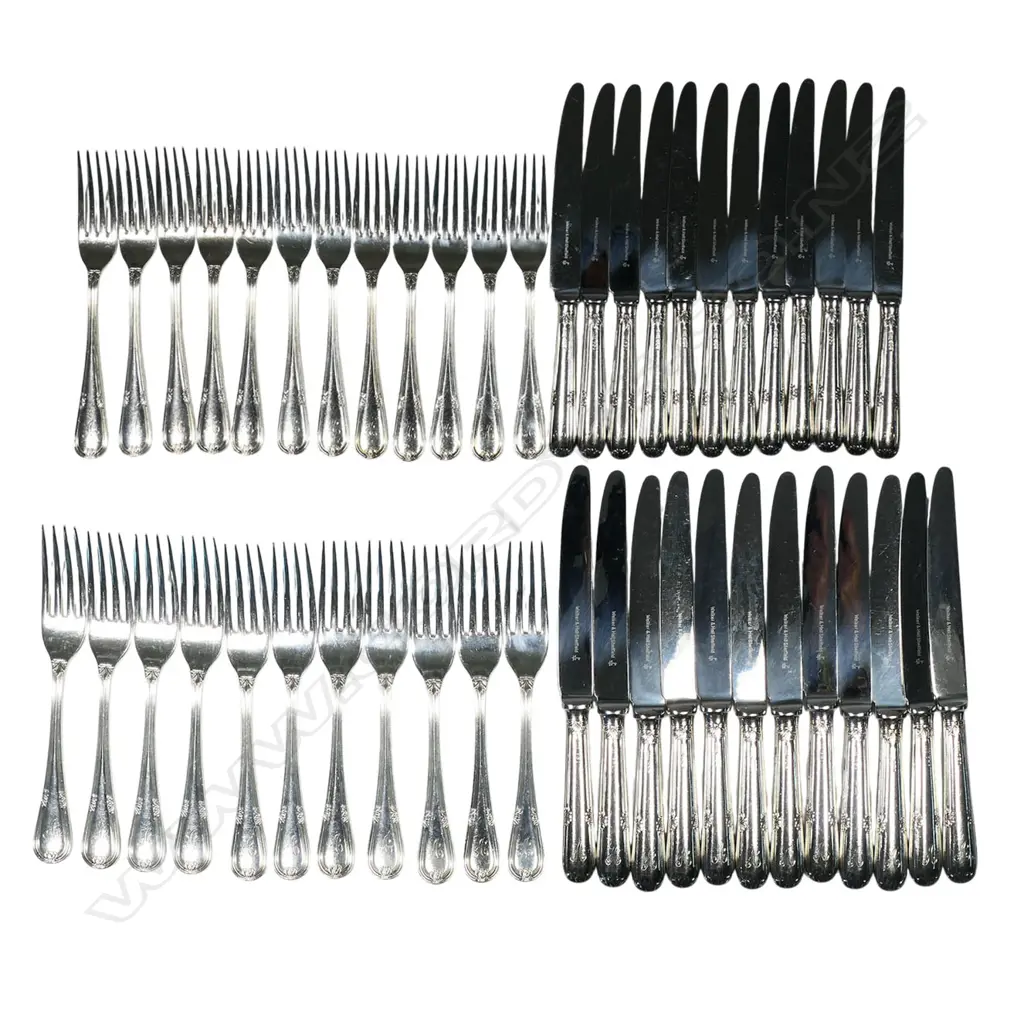 A 12 place 90-piece silver cutlery canteen by Walker and Hall, with eight additional silver plated serving utensils, Sheffield 1972 - double struck leaf and berry pattern with thread edge. Comprising 12 each: table forks, entree forks, dessert spoons, soup spoons, teaspoons, with six table spoons and 12 silver handled stainless bladed table knives and 12 entree knives. Total weight excluding knives 4255gms. Image 1++