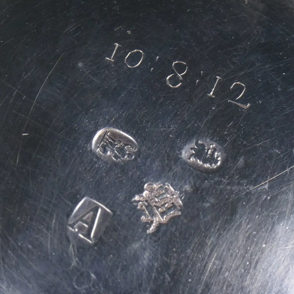 A rare and early George I silver mug -the plain body with an elaborately framed cartouche enclosing scripted initials. Double scroll handle. H.110mm. London 1716 by William Fleming a noted mug maker. 296grms. Image 1++