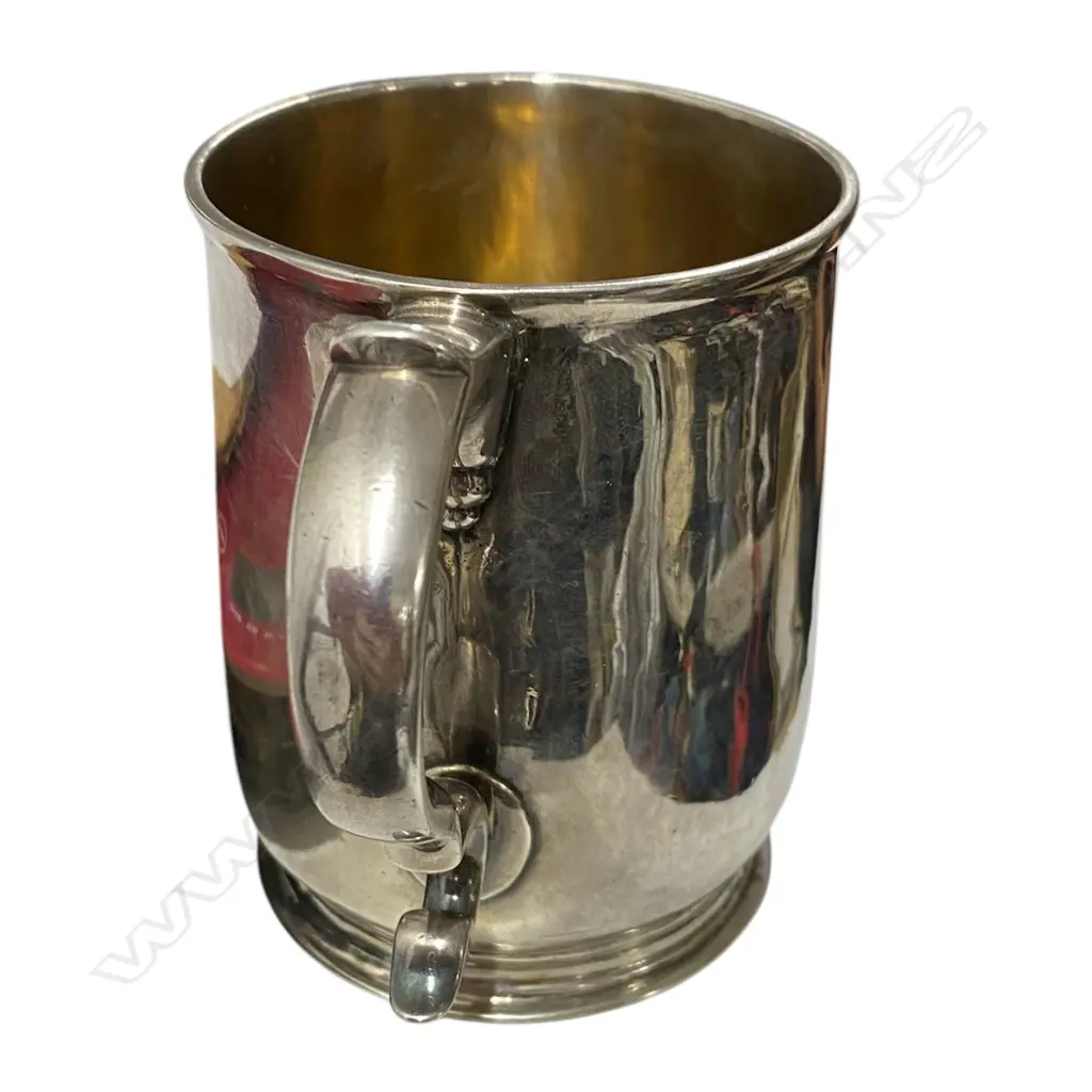 A rare and early George I silver mug -the plain body with an elaborately framed cartouche enclosing scripted initials. Double scroll handle. H.110mm. London 1716 by William Fleming a noted mug maker. 296grms. Image 1++
