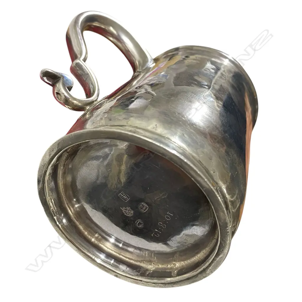 A rare and early George I silver mug -the plain body with an elaborately framed cartouche enclosing scripted initials. Double scroll handle. H.110mm. London 1716 by William Fleming a noted mug maker. 296grms. Image 1++