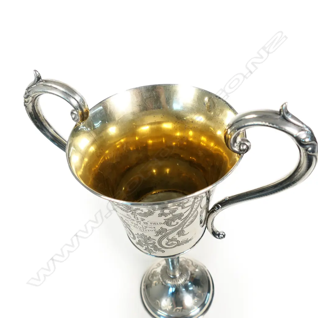 The New Zealand historic 1886 and 1890 silver 'Papakaio Ploughing Match' trophy cup - 'Won by AlexR. Hall'. Engraved to the reverse 'CUP For Champion Lot On Field to Be Won Twice by Same Competitor'. Large scrolling handles. Edinburgh 1882 for G & T Young Dunedin. H.325mm. 523gms. With stand. Image 1++