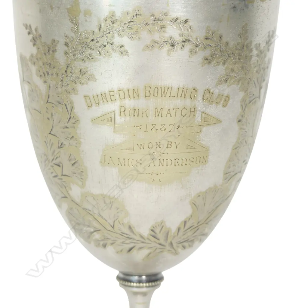 A late 19thC New Zealand historical silver plate trophy cup, presentation engraved ' Dunedin Bowling Club Rink Match 1887 Won By James Anderson. The front engraved with a bowling scene. The plating worn. H.210mm. Image 1++